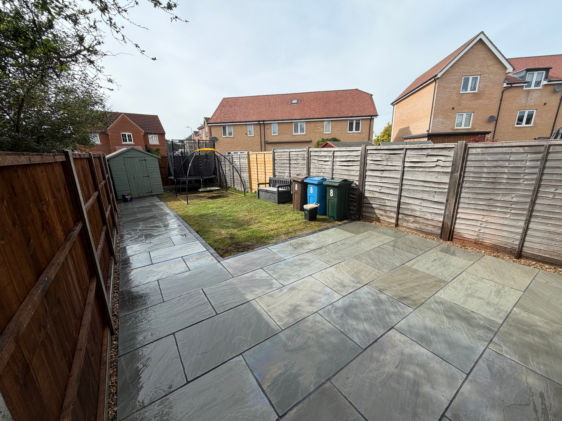 Swale garden after — wide view of finished patio and lawn