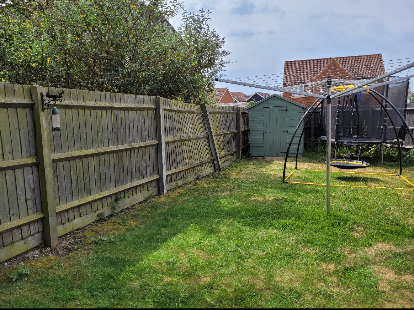 Swale garden before — tired lawn and leaning fence